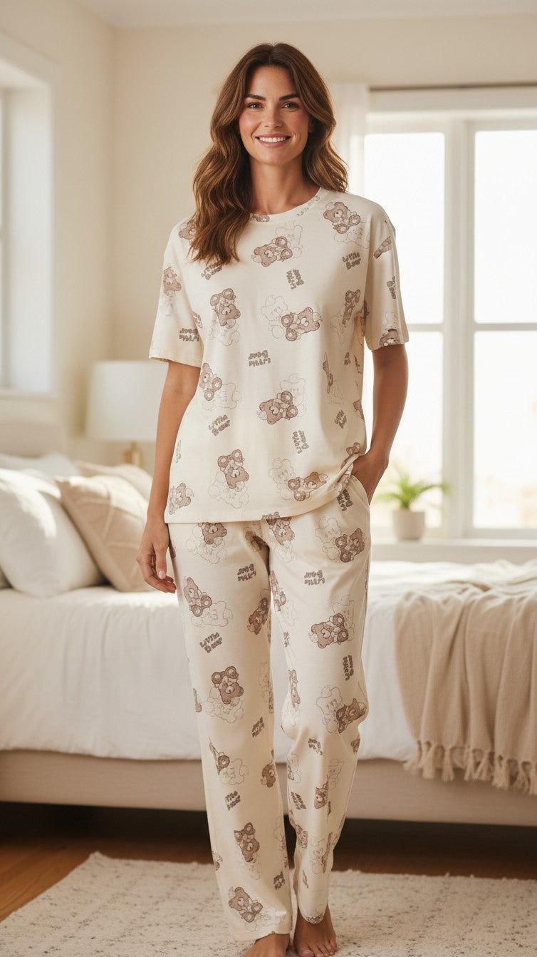 Woman wearing a cream Night Suits By Aaka two-piece loungewear set with a whimsical brown little bear print pattern.